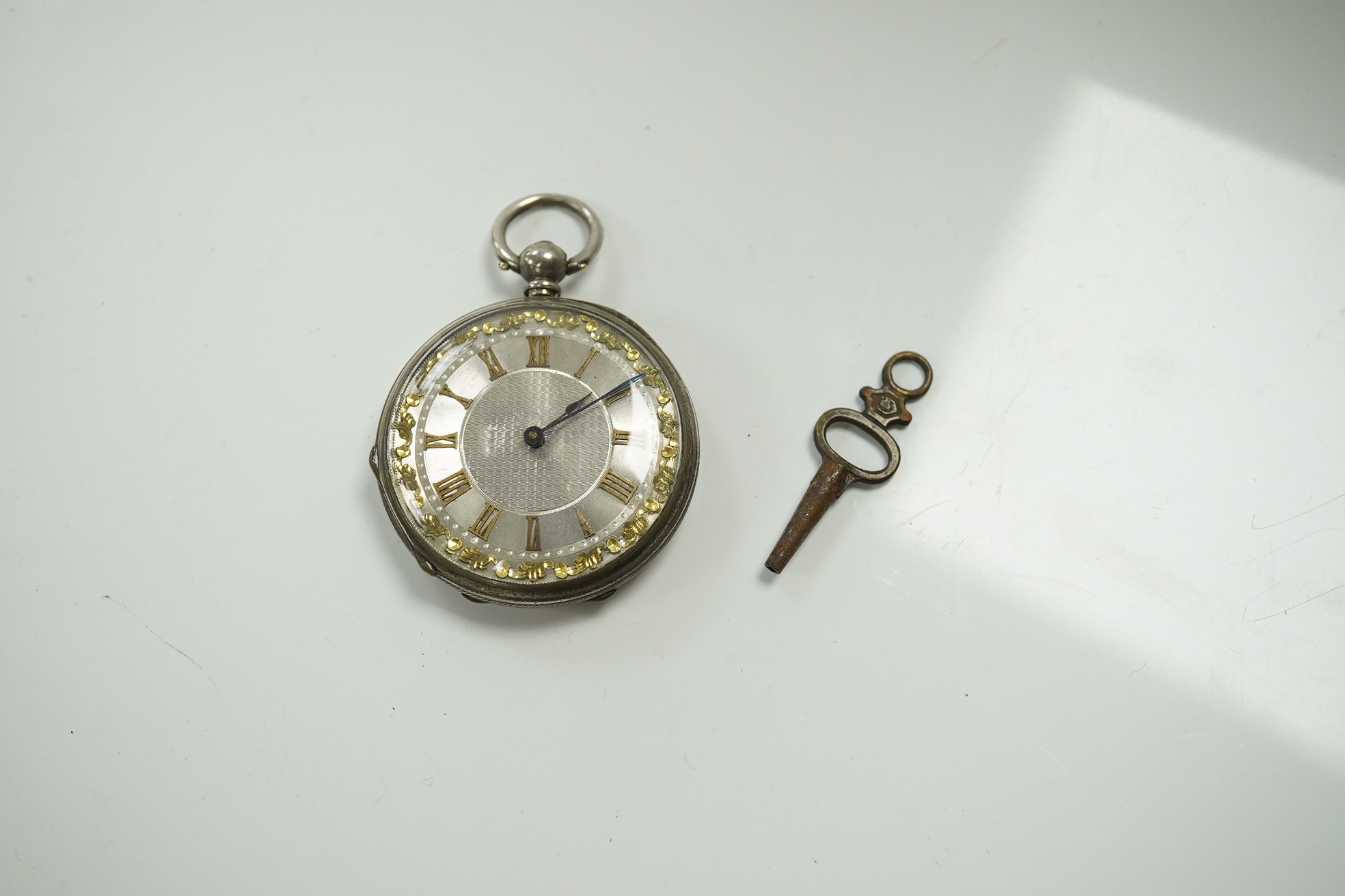 A group of assorted small silver wares including two vesta cases and two napkin rings, 5oz. of weighable silver, a mother of pearl handled butter knife, three pepperettes and a 19th century silver keywind fob watch. Cond